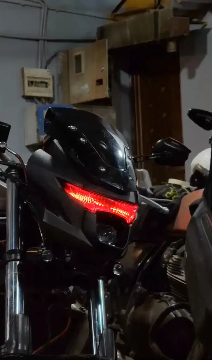 Black streetfighter motorcycle with custom red LED headlight strip