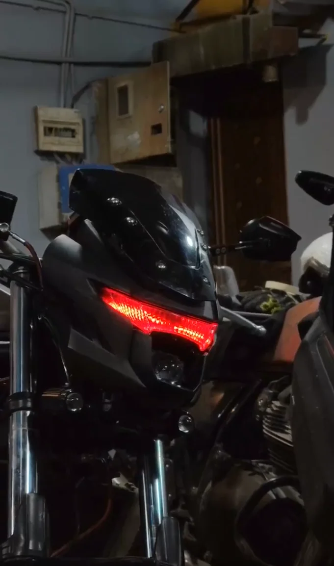 Black streetfighter motorcycle with custom red LED headlight strip